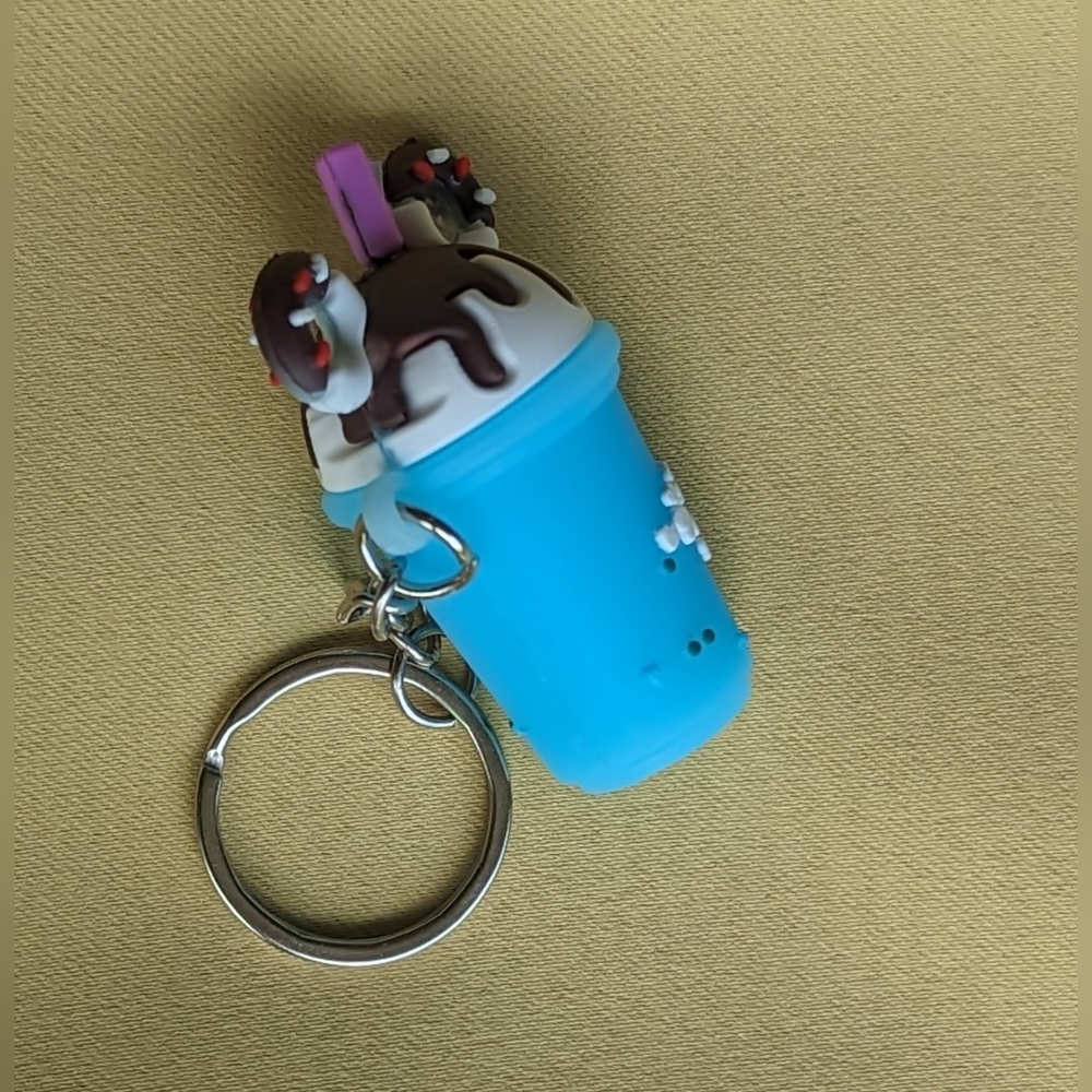 New silver tone keychain blue bubble tea cup with flowers & donuts atop milk tea